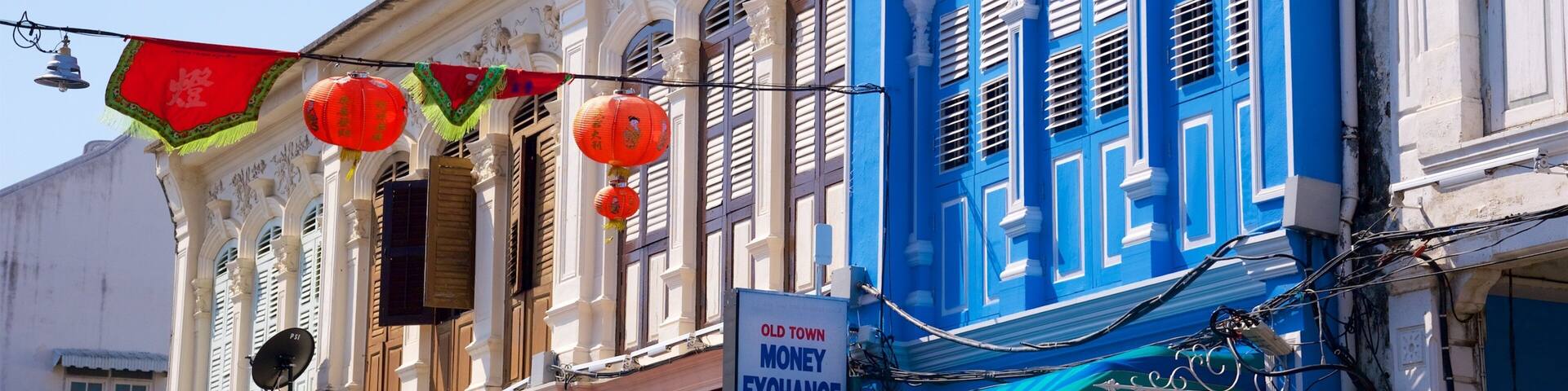 A traditional building with ornate architecture, a sign for an old town money exchange, and red lanterns hanging outside.