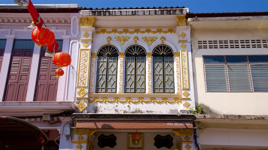 A building with ornate gold detailing, large arched windows, and red lanterns.