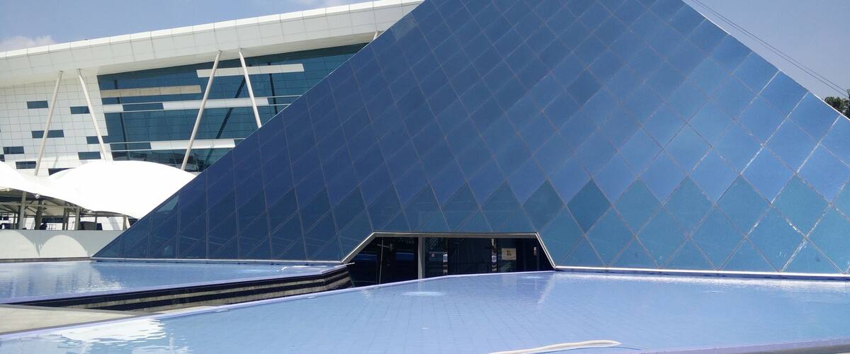 A modern building with a triangular glass facade.