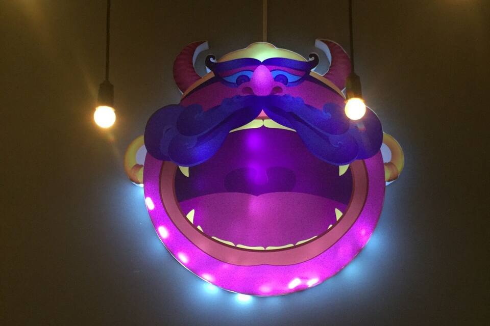 En färgstark, upplyst skulptur som föreställer ett mytologiskt väsen med horn och en rund kropp.