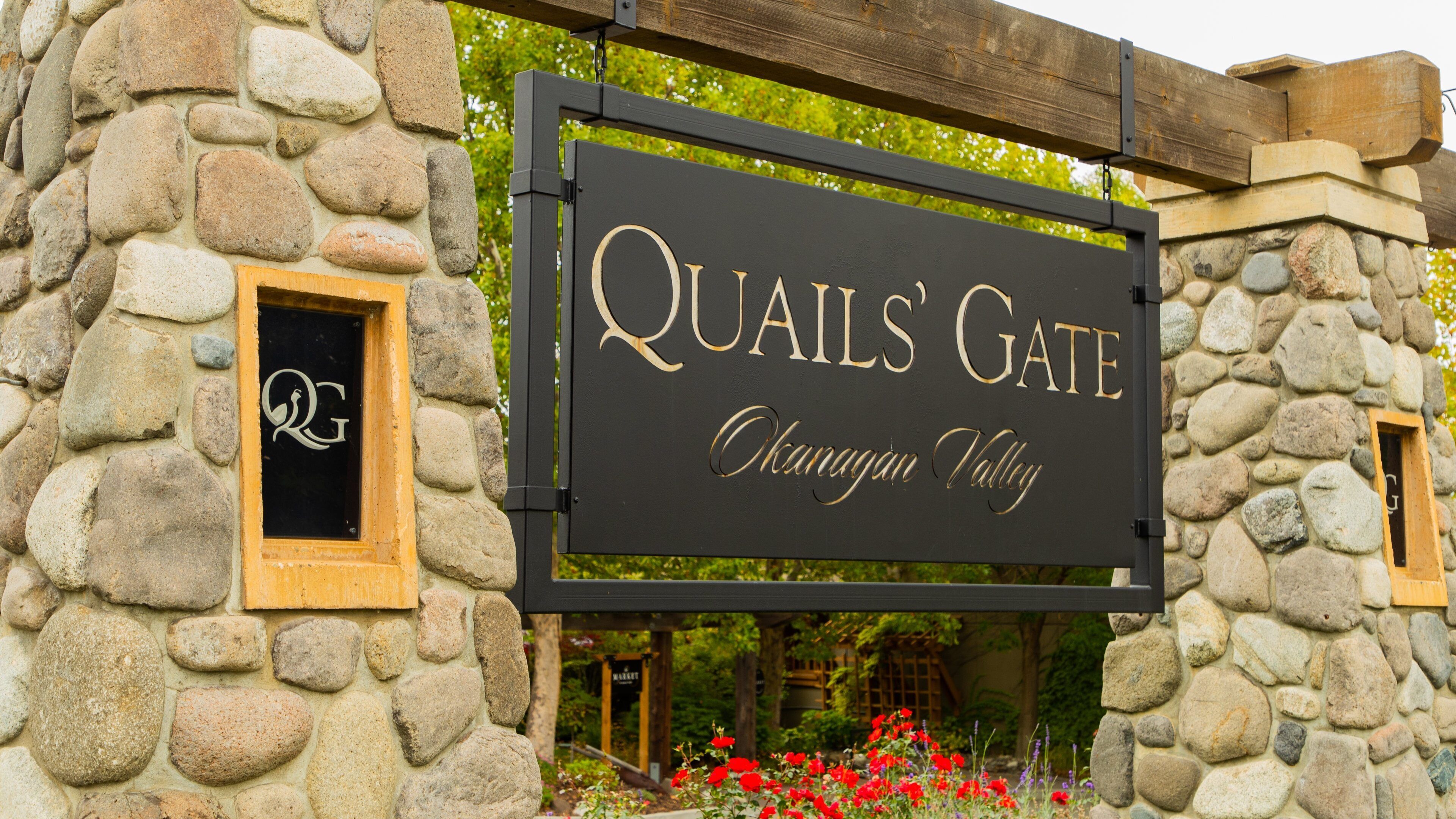 A stone wall with a sign that reads "Quails' Gate" and "Okanagan Valley".
