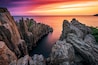 A coastal rock formation with a narrow water channel.