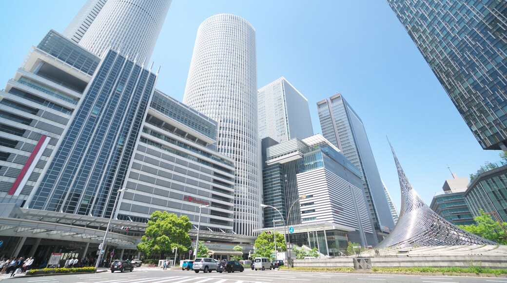 A cityscape with modern skyscrapers, a clear blue sky, and a pedestrian crossing.