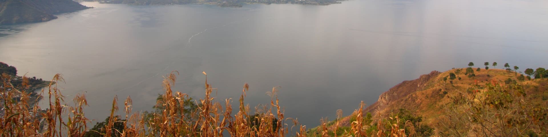 A lake surrounded by mountains with a cloudy sky.