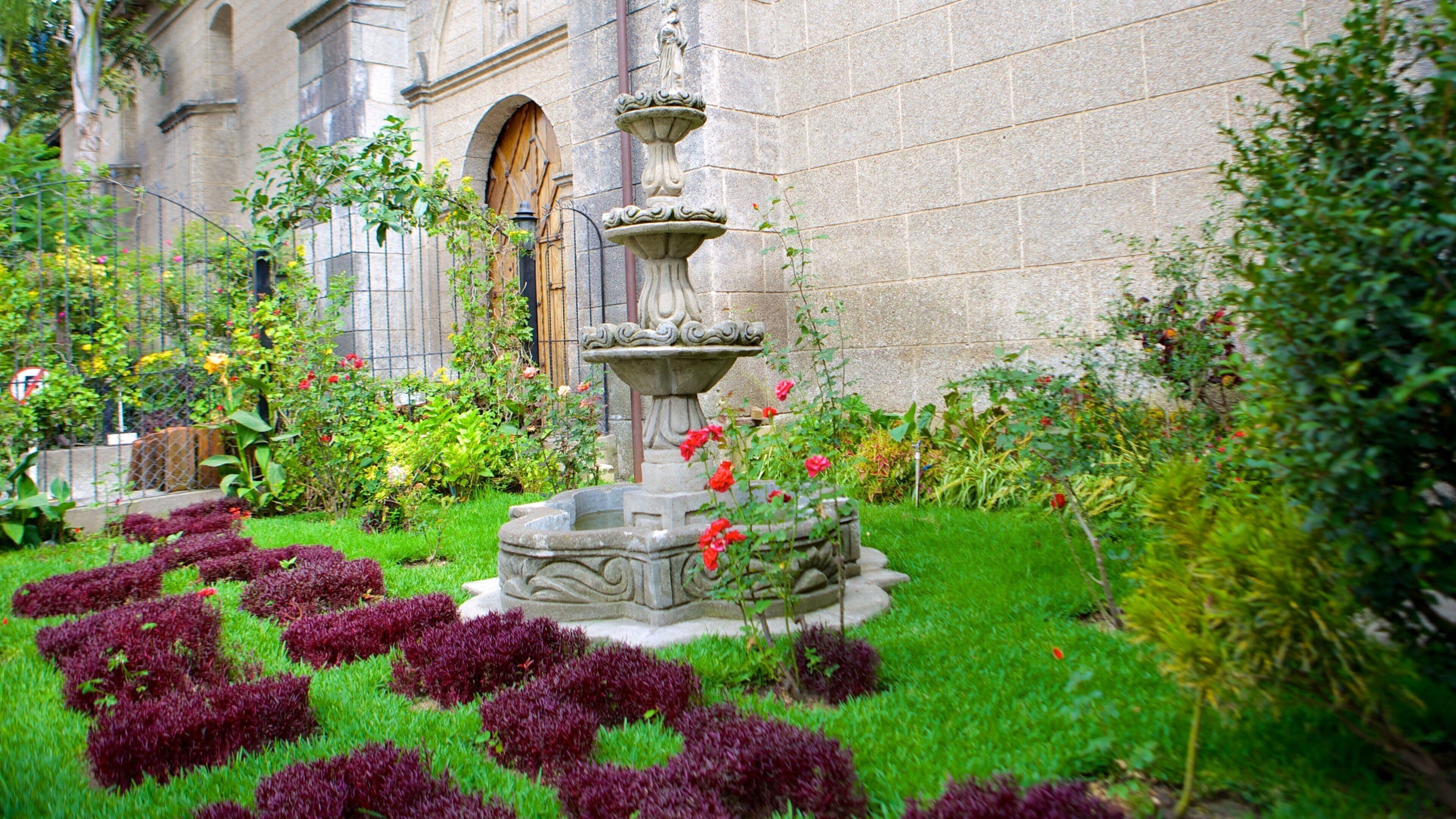 Iglesia Católica San Francisco de Asís som visar en fontän och en trädgård