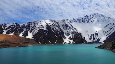 Cordillera nevada con un lago turquesa.