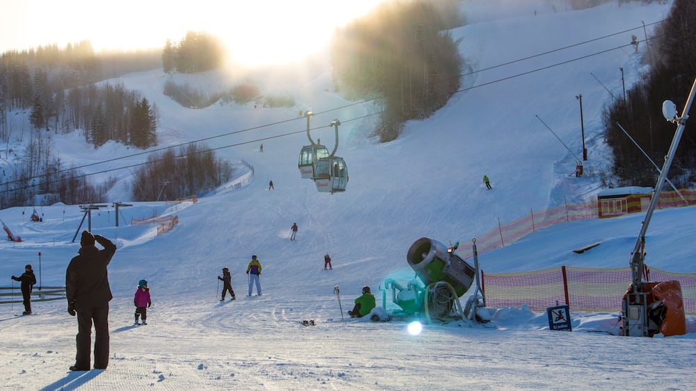 A ski slope with a ski lift, skiers, and a snow-covered landscape.