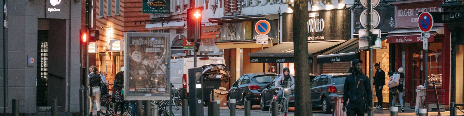 A city street with buildings, a no parking sign, and a bus stop.