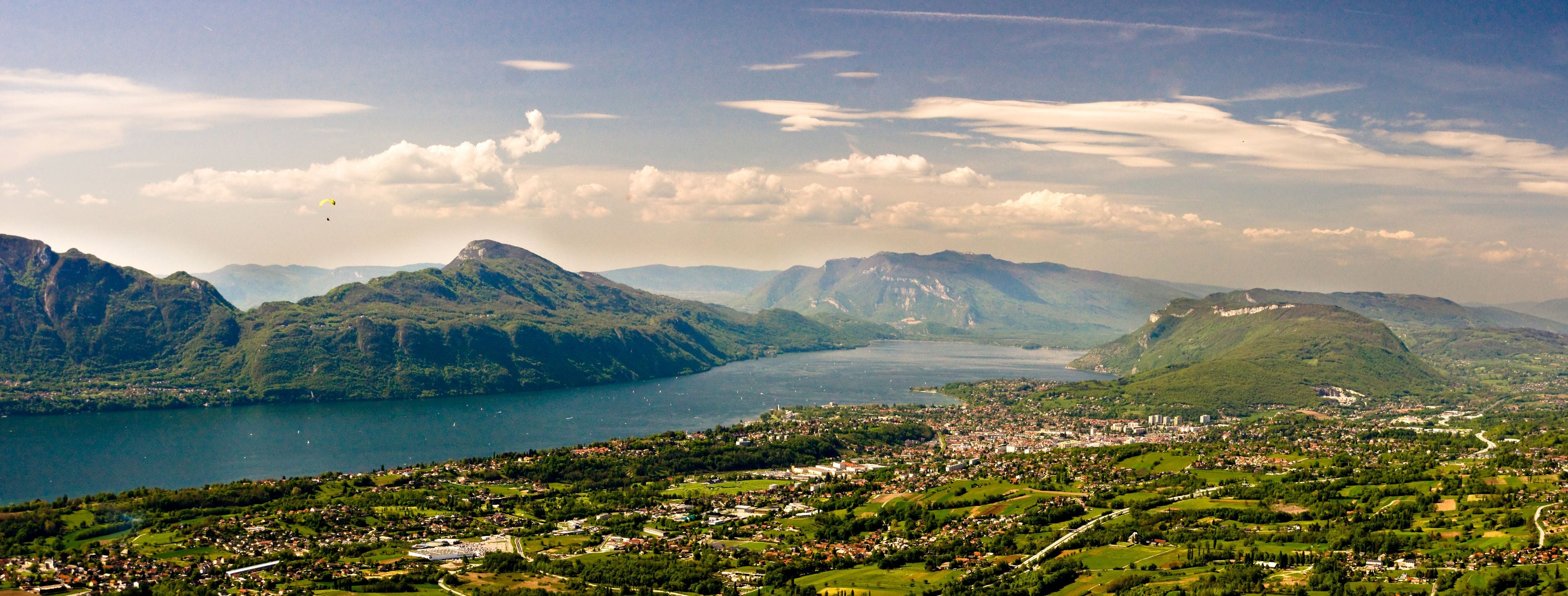 A mountainous landscape with a lake and a town in the foreground.
