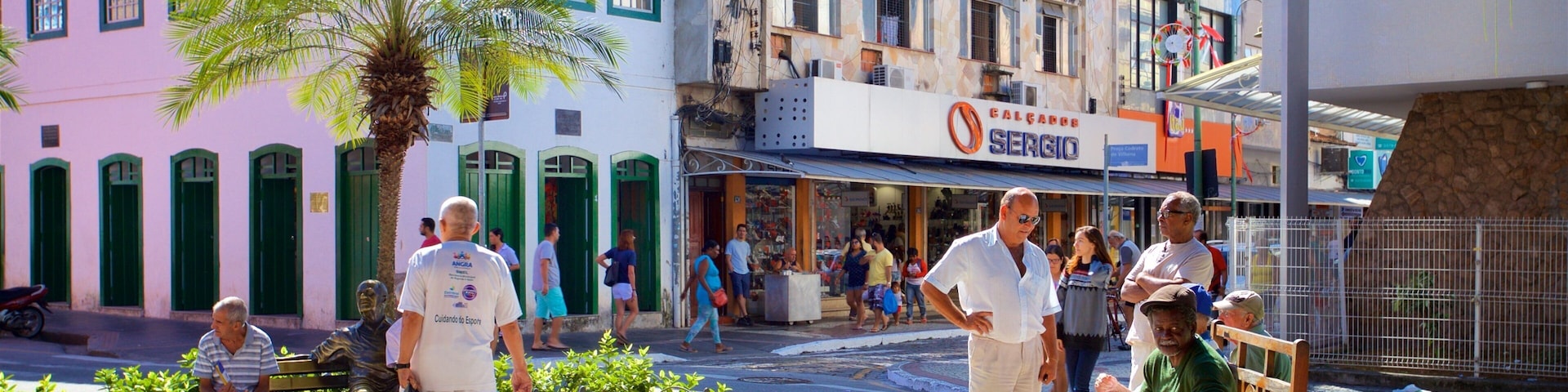 Praça Nilo Peçanha que inclui um jardim assim como um pequeno grupo de pessoas