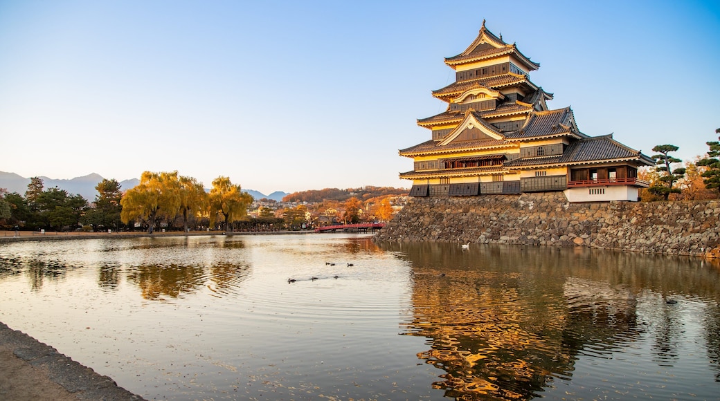 Matsumoto Castle featuring a pond, heritage architecture and a sunset