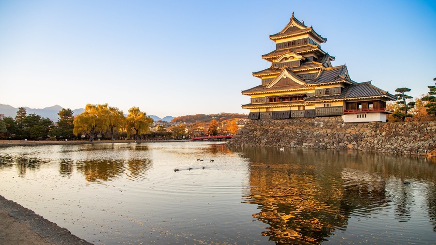 Matsumoto Castle featuring a pond, heritage architecture and a sunset