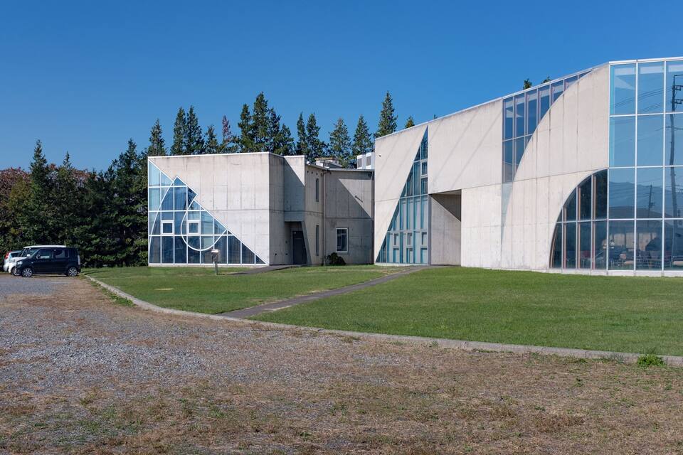 Um edifício moderno com amplas janelas de vidro e formas geométricas.