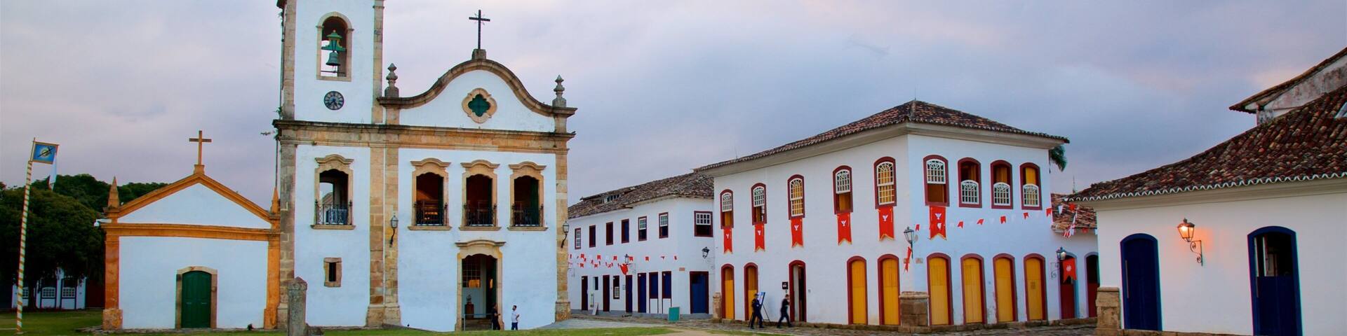 A historic church with a bell tower and a courtyard with buildings.