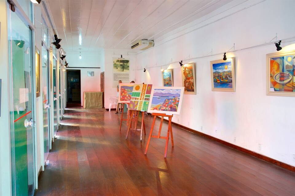 Eine Kunstgalerie mit Holzböden und Gemälden an den Wänden.