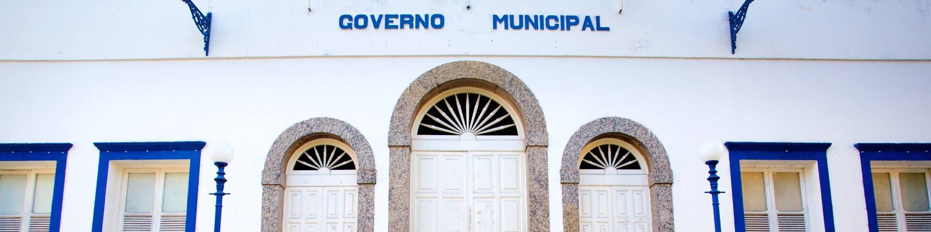 A building with the sign "GOVERNO MUNICIPAL" above a set of stairs leading to a white door with a fanlight above it.