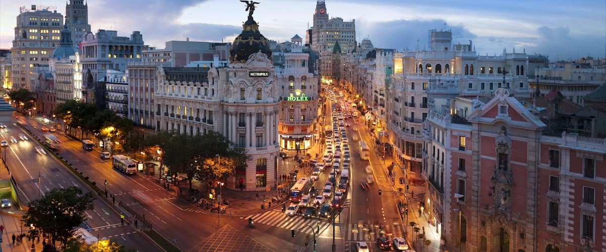 Vibrant sunset over bustling Gran Via showcasing architecture and urban life in Madrid