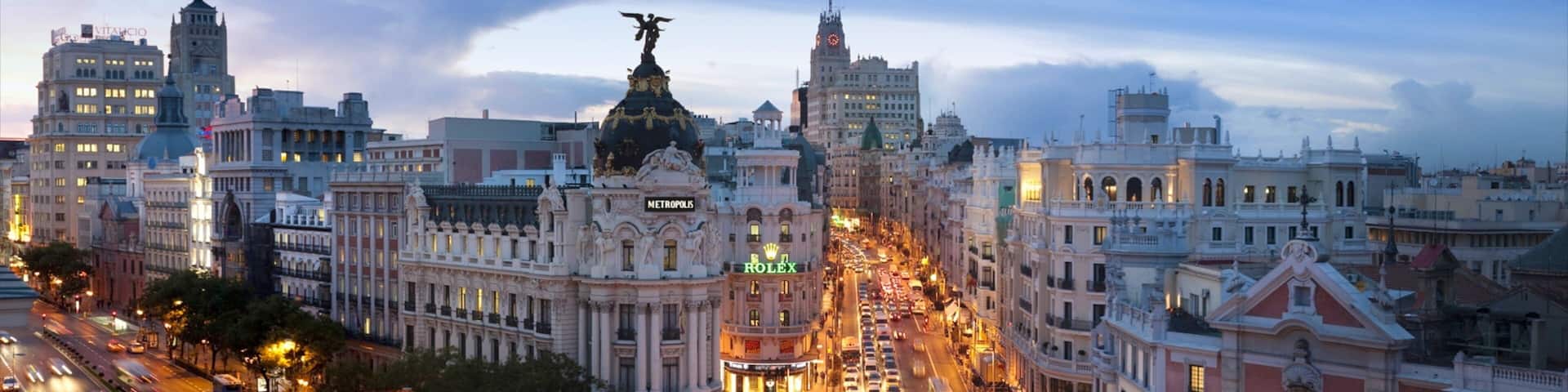 Vibrant sunset over bustling Gran Via showcasing architecture and urban life in Madrid