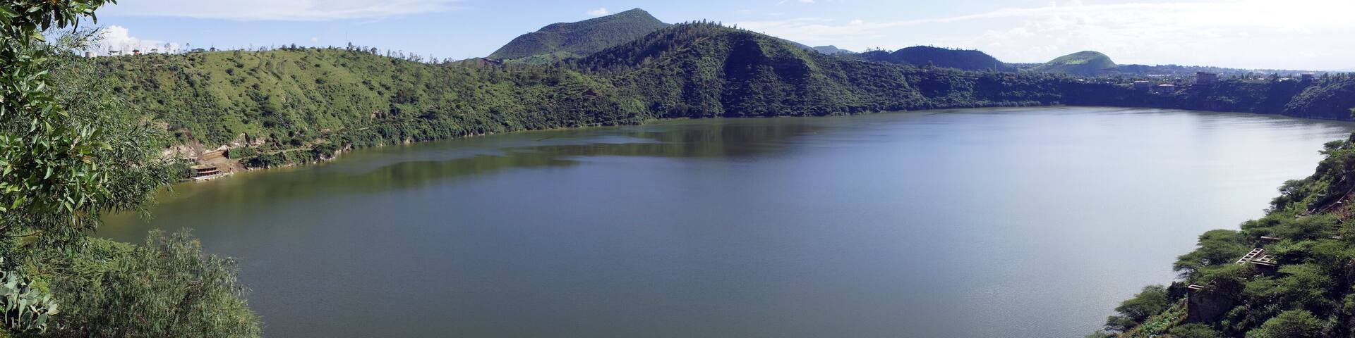 Panoramic view encompassing the forested and hilly shores of Lake Bishoftu, a crater lake in central Ethiopia south of Addis Ababa
