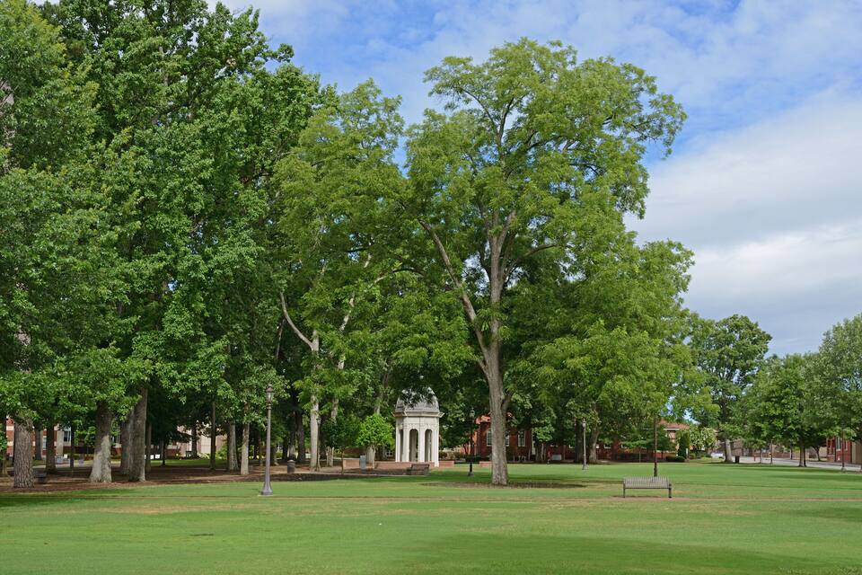 A park with a gazebo, trees, and a lawn.