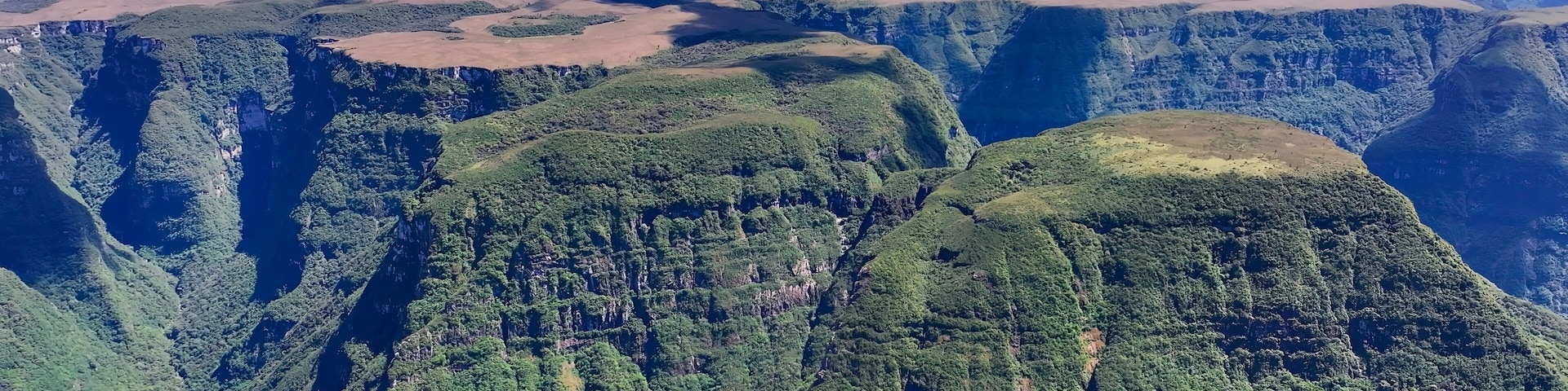 A mountainous landscape with dense forests and deep valleys.