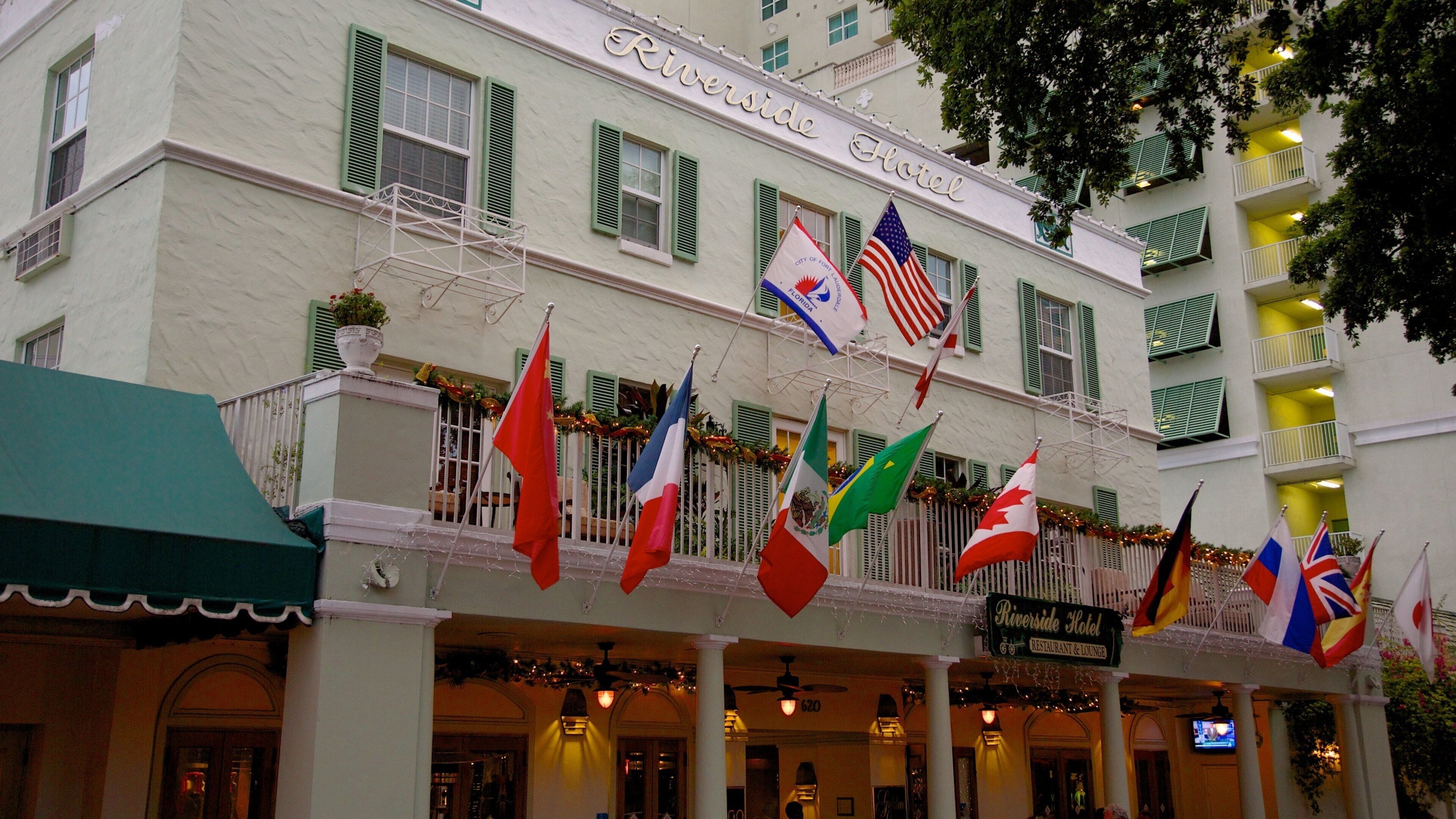 L’hôtel Riverside, reconnaissable à ses nombreux drapeaux, dont les drapeaux américain et canadien, ainsi qu’à une enseigne indiquant l’emplacement du restaurant et du bar.