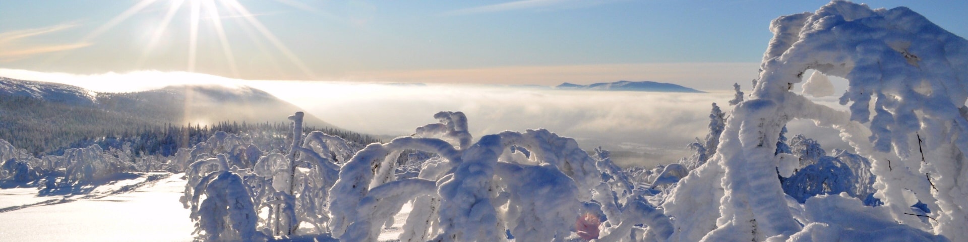 Paisaje nevado con formaciones de hielo y cielo iluminado por el sol.