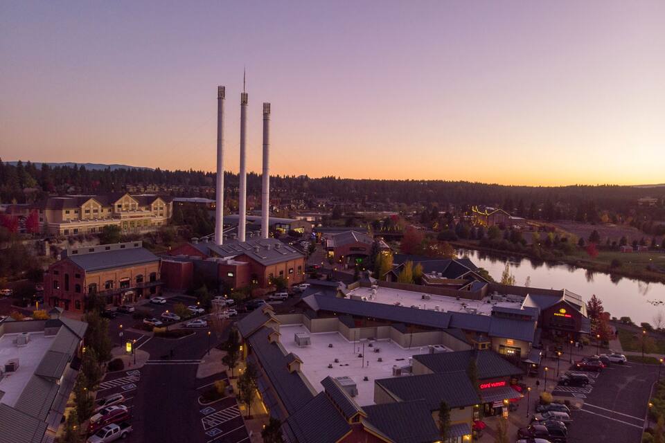 Une ville riveraine, avec des bâtiments industriels, un grand hôtel et un parking.