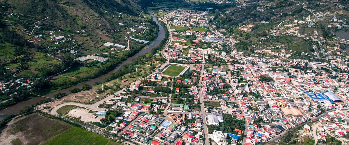 An aerial view of a town nestled in a valley with a river running through it.