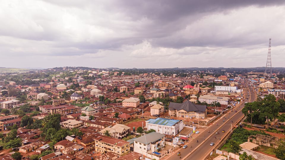 A cityscape with a prominent road, various buildings, and a tall communication tower.