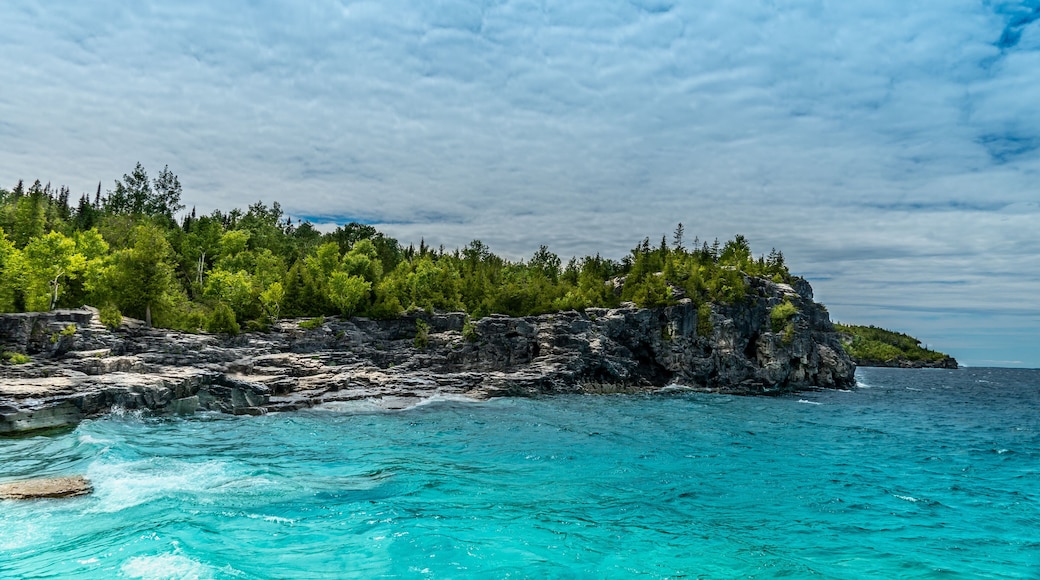 Panorama view of summer Georgian bay at Tobermory Ontario, Canada. Lake Huron and turquoise blue green transparent crystal clear water with rocky bottom formations. Indian Head Cove landscape.