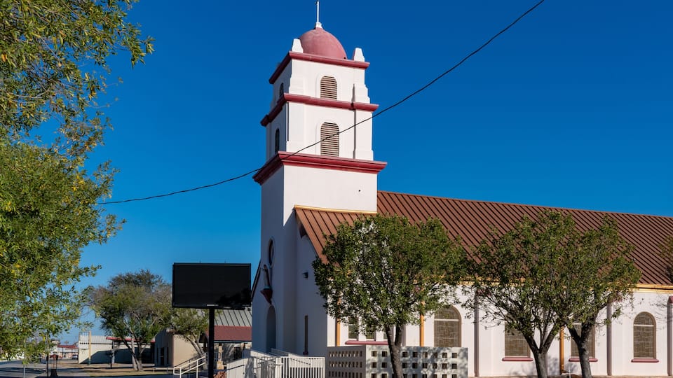 A white church with a red roof and a bell tower.
