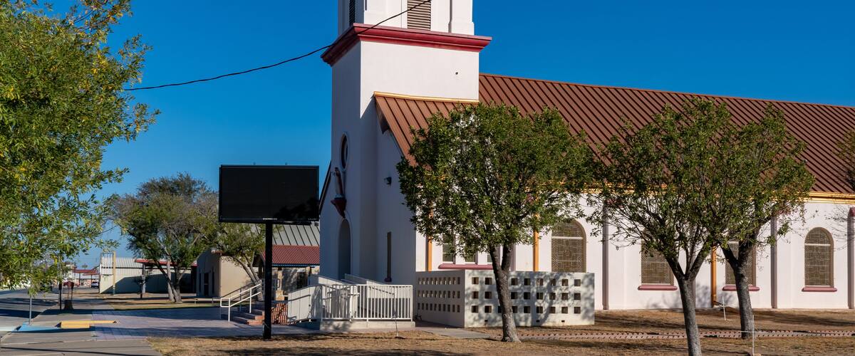 A white church with a red roof and a bell tower.
