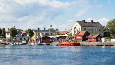 A harbor with boats, a red boat, and colorful buildings along the waterfront.