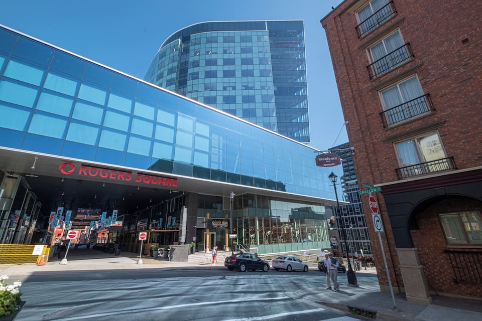 A modern building with a glass facade and a sign for Rogers Square.