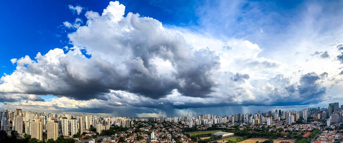 A cityscape with a large cloud formation and a stormy sky.