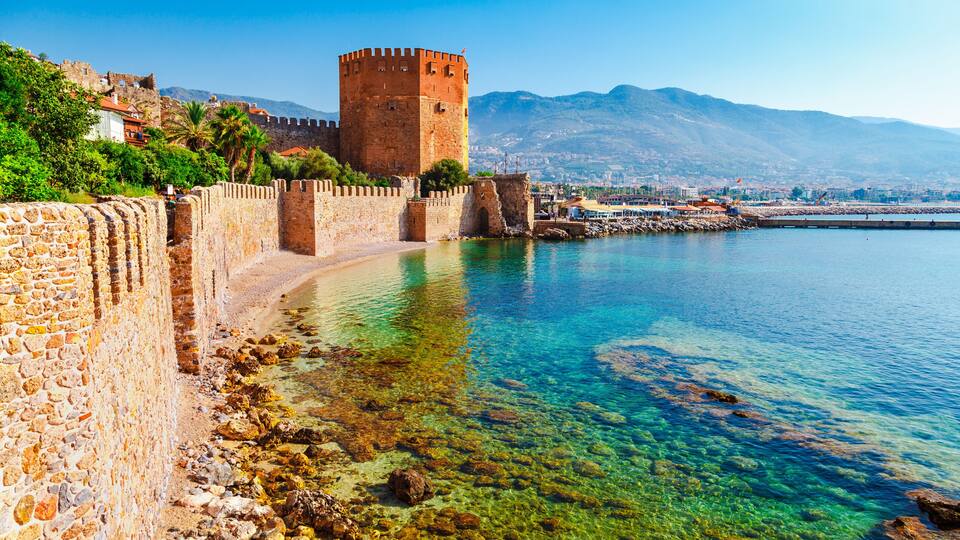 Kizil Kule tower in Alanya peninsula, Antalya district, Turkey, Asia. Famous tourist destination with high mountains. Part of ancient old Castle. Summer bright day
