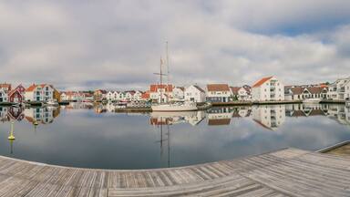 Houses and boats are reflected in the water