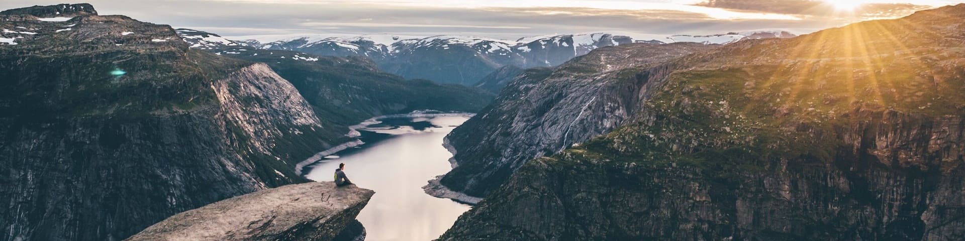 A mountainous landscape with a river flowing through a valley, surrounded by rugged cliffs.