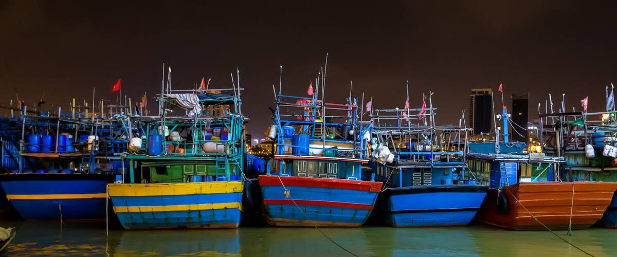 A dock with several colorful boats tied up.
