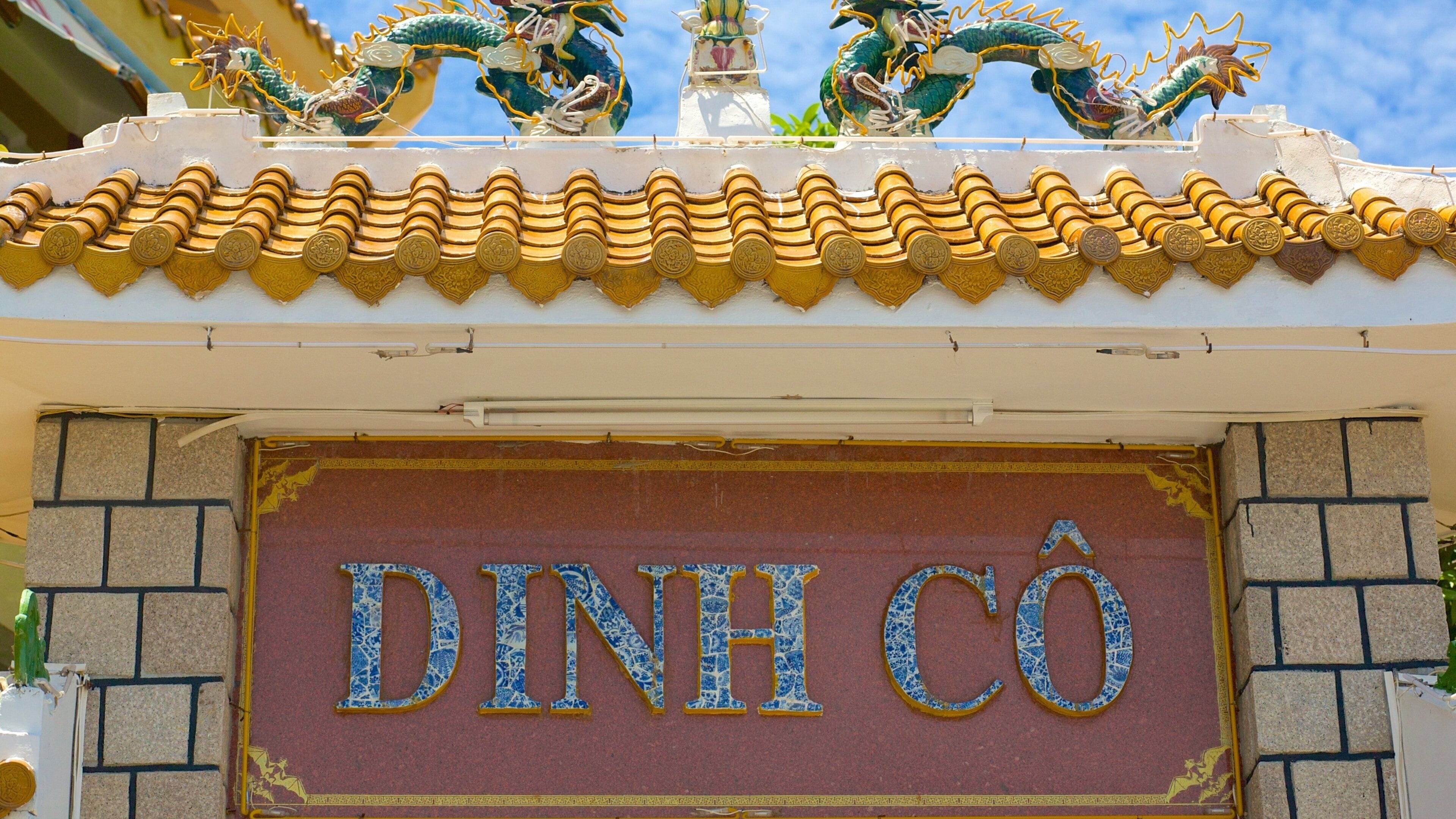 A building with a tiled roof and a sign that reads "DINH CÔ".