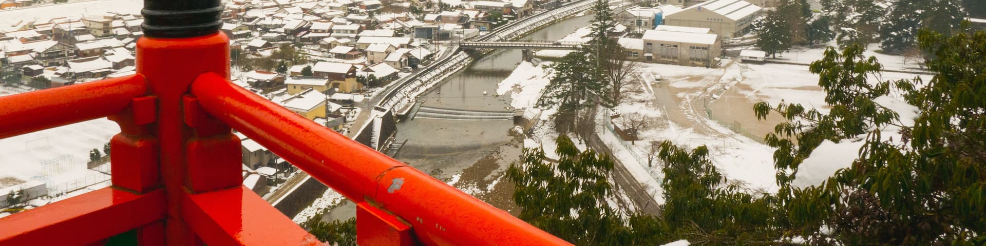 A snow-covered town with a river, surrounded by mountains.