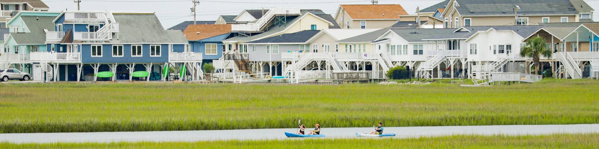 A coastal area with houses and a marshy landscape.