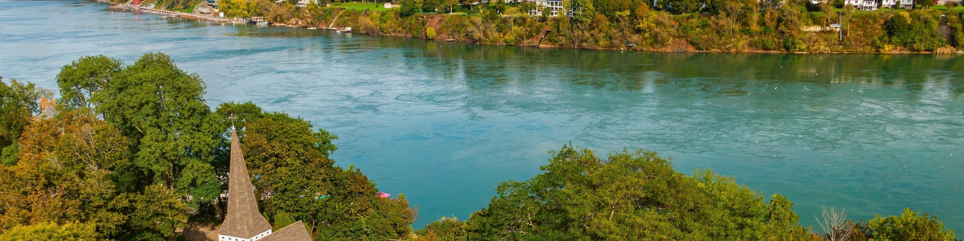 A church surrounded by trees and a river.