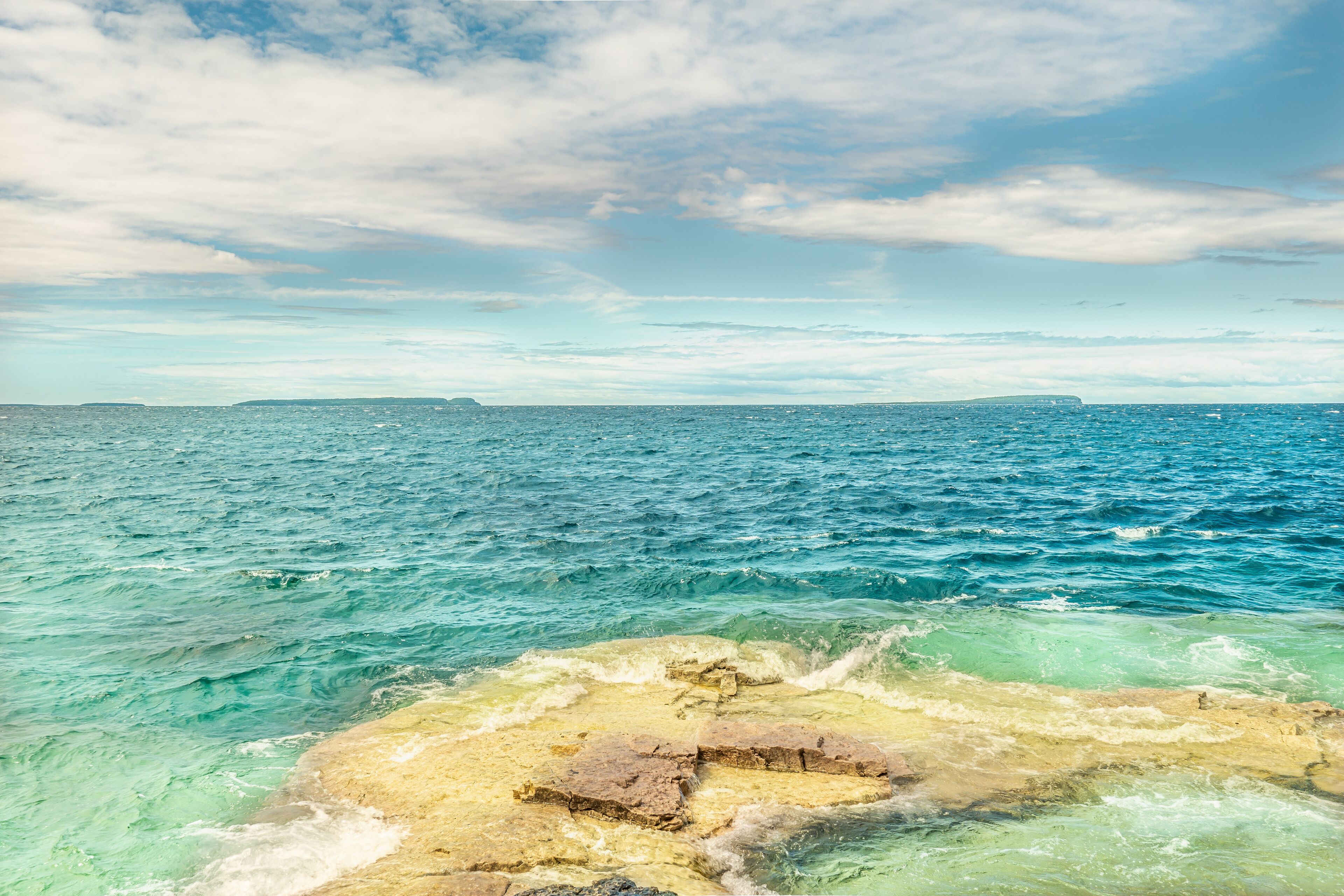 Panorama view of summer Georgian bay at Tobermory Ontario, Canada. Lake Huron and turquoise blue green transparent crystal clear water with rocky bottom formations. Indian Head Cove landscape.