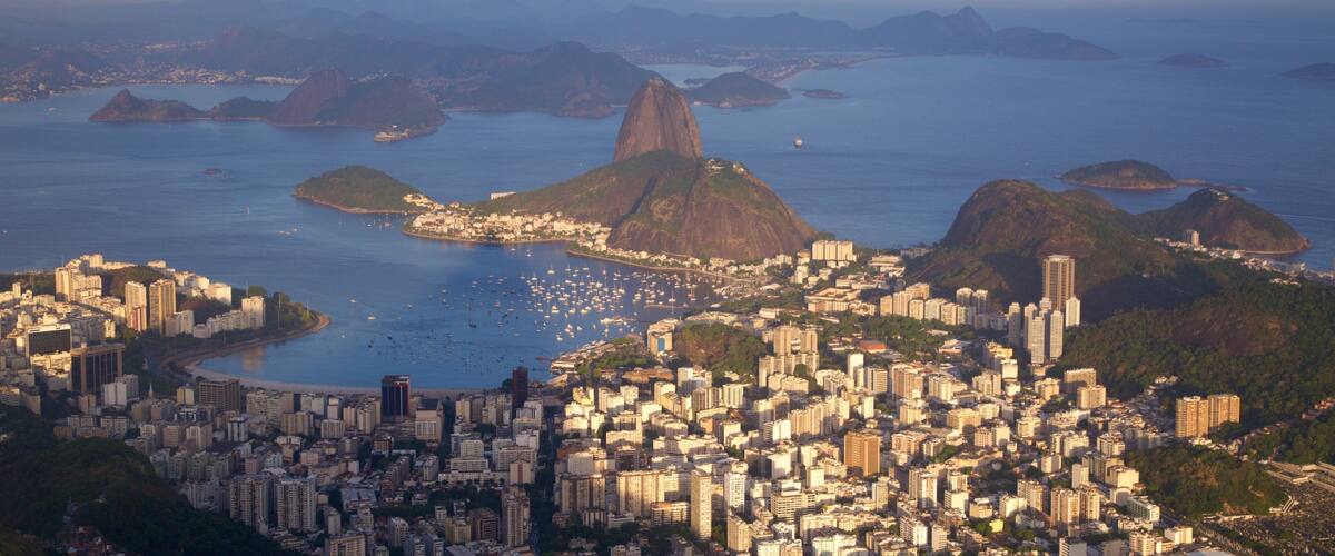 A cityscape with a prominent mountain and a harbor filled with boats.