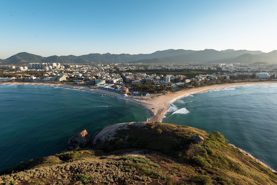 Una ciutat costanera amb platja, muntanyes i edificis residencials.