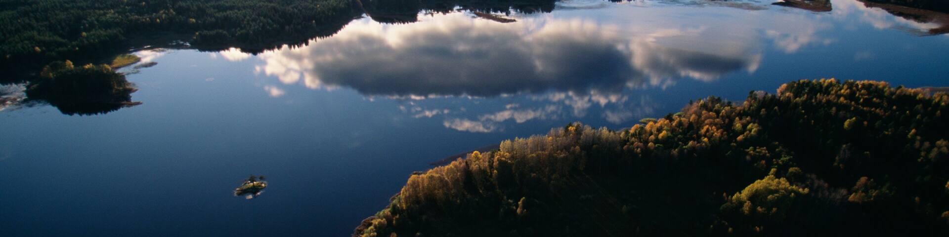 A lake surrounded by forested areas with a small island in the center.