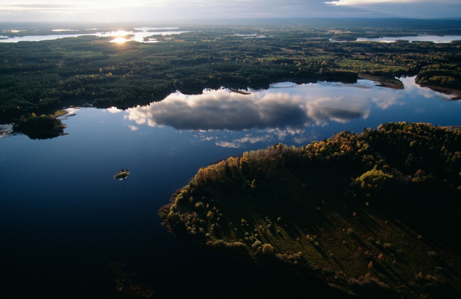 A lake surrounded by forested areas with a small island in the center.