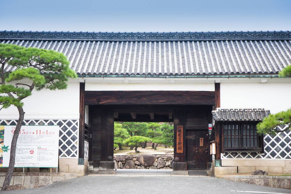 Ein traditionelles japanisches Tor mit einem Ziegeldach und hölzernen Säulen.